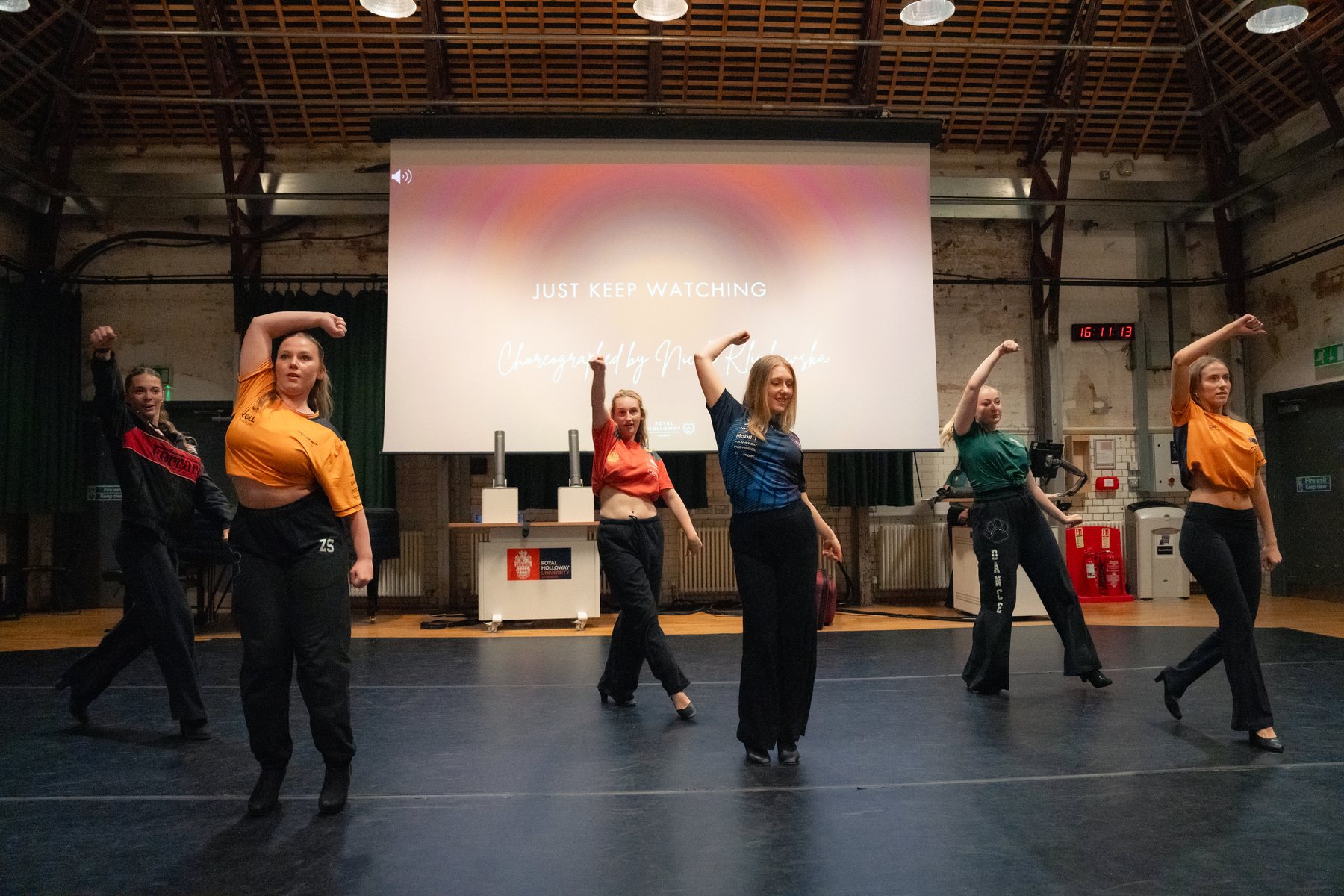 Dance group with arms raised on stage