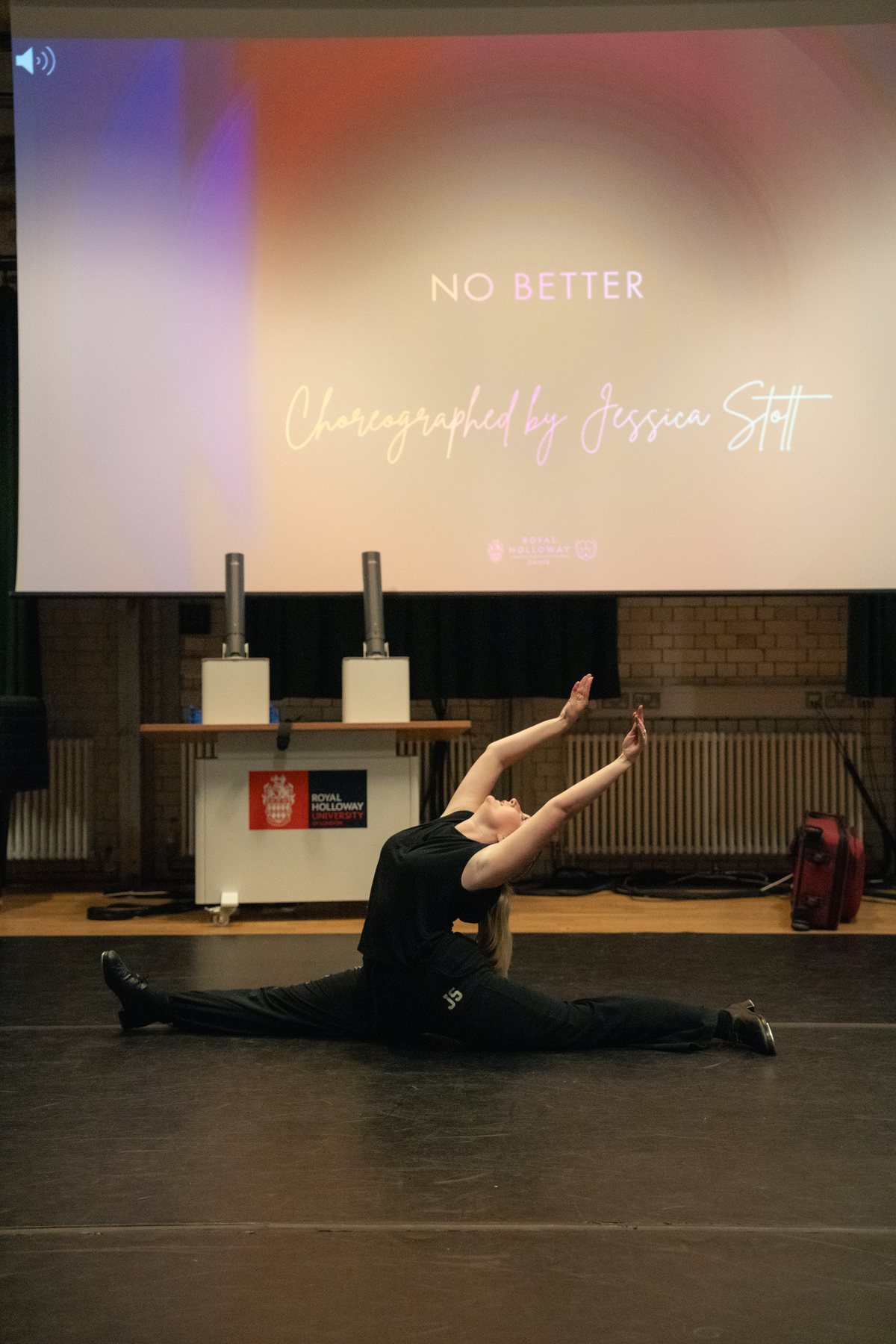Dancer in a full floor split on stage