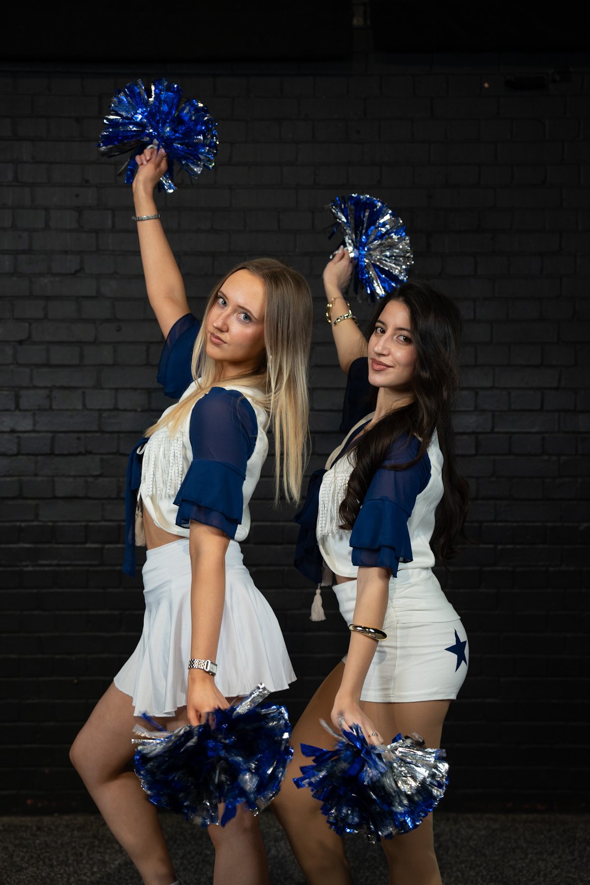 Two friends with pom-poms raised