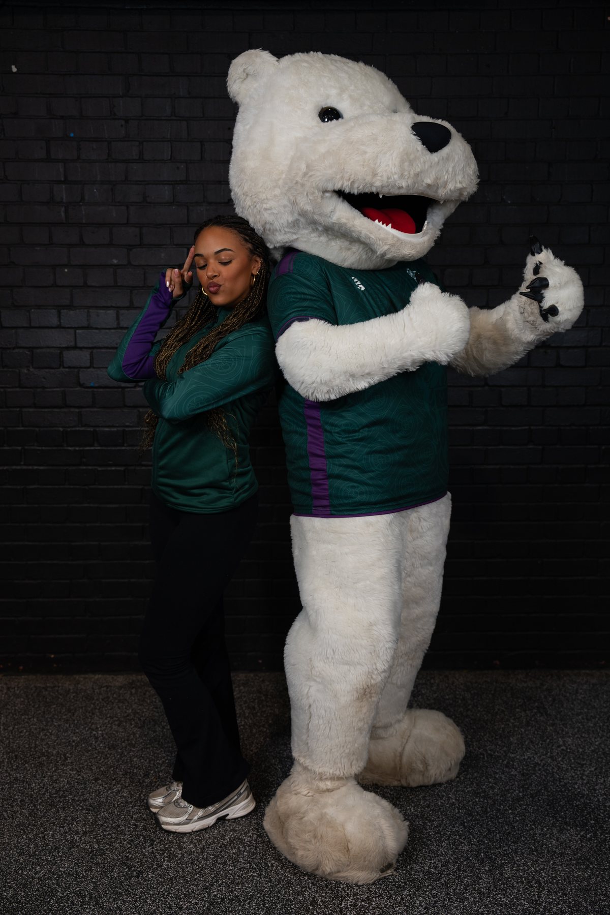 Friend posing back-to-back with the university mascot