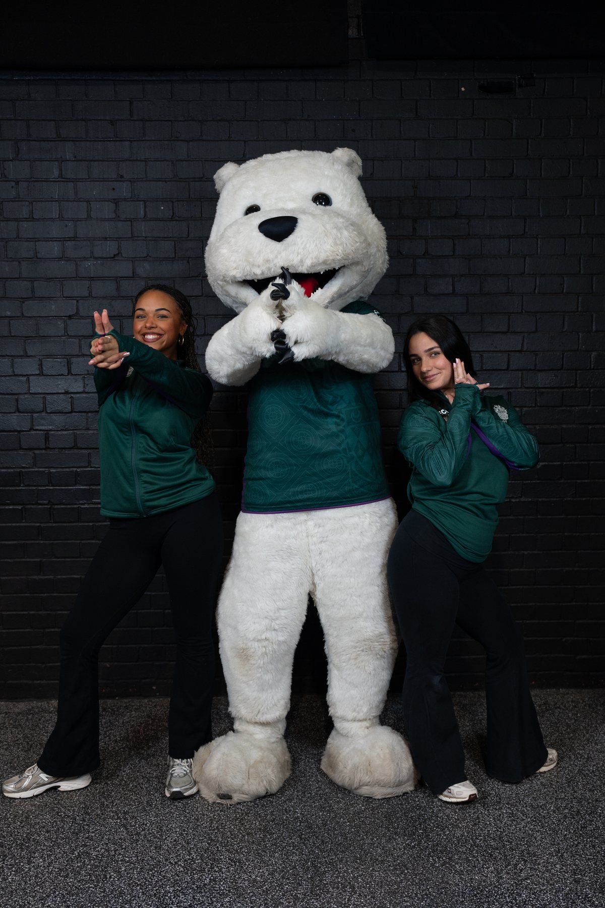 Friends posing with the university mascot